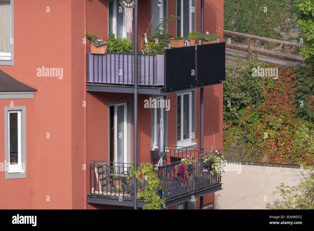 Façade rouge et balcons avec décorations florales et panneaux solaires, Kempten, Allgaeu, Souabe, Bavière, Allemagne Banque D'Images