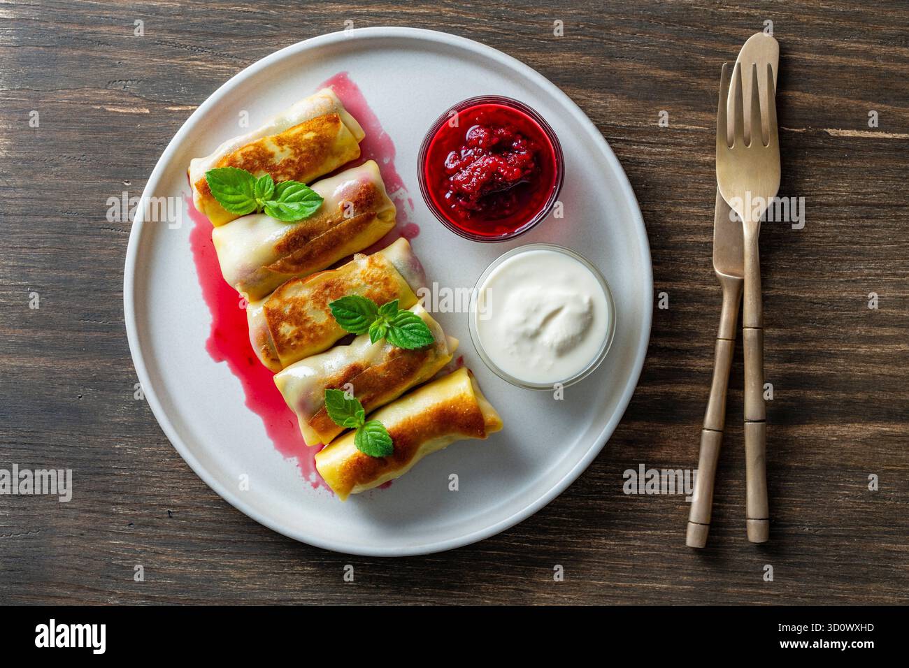Crêpes roulées frites farcies de fromage cottage et de cerise, dessert sucré sur assiette, gros plan, vue de dessus. Pâtisserie maison. Délicieux fast-food pour bre Banque D'Images