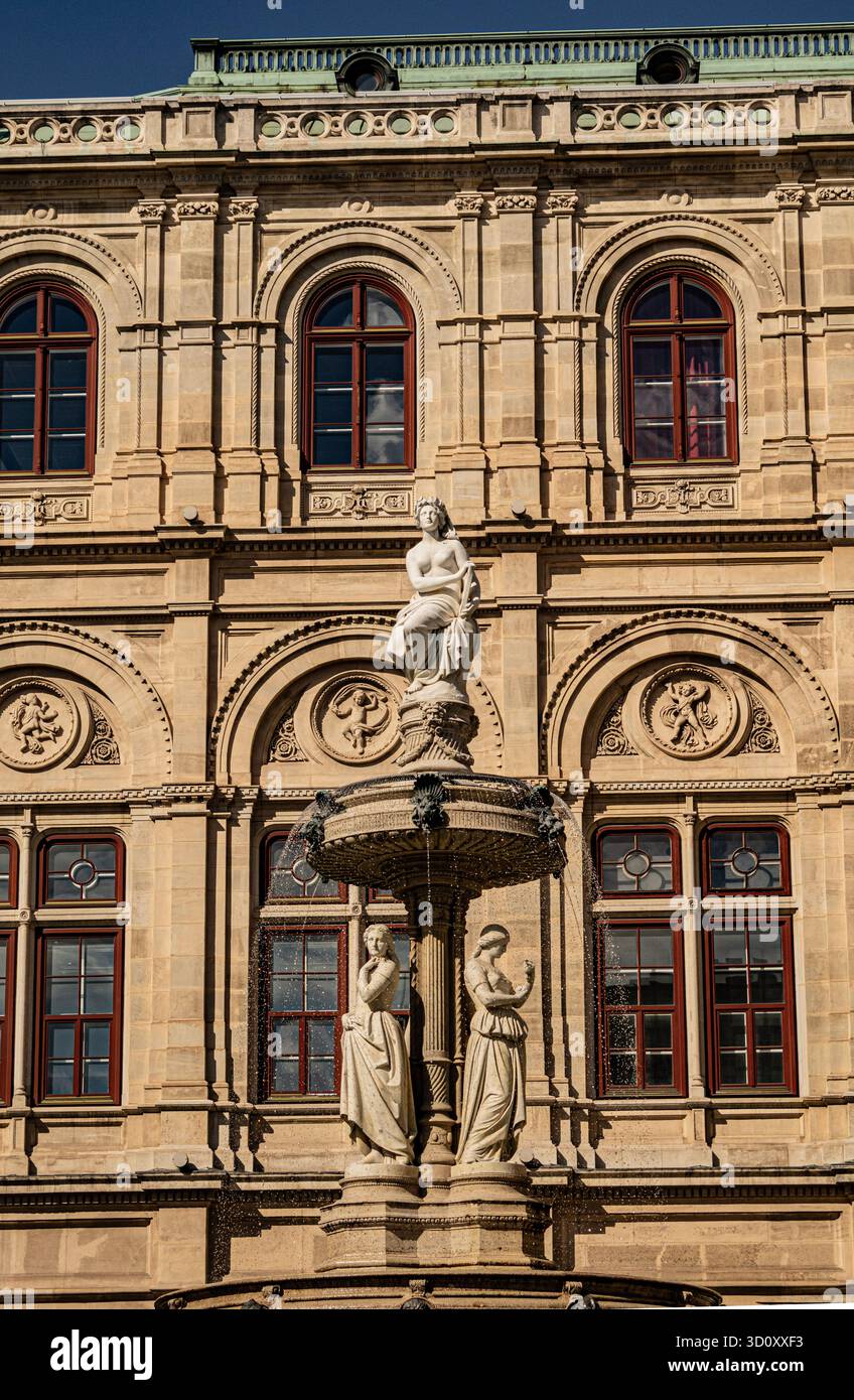 Vue rapprochée et détaillée de l'Opéra national de Vienne (Wiener Staatsoper) présentant les fenêtres rouges, l'architecture ornée et une fontaine extérieure Banque D'Images
