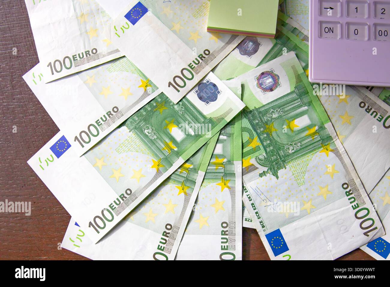 Cent billets en euros avec stylo jaune sur fond en bois Banque D'Images
