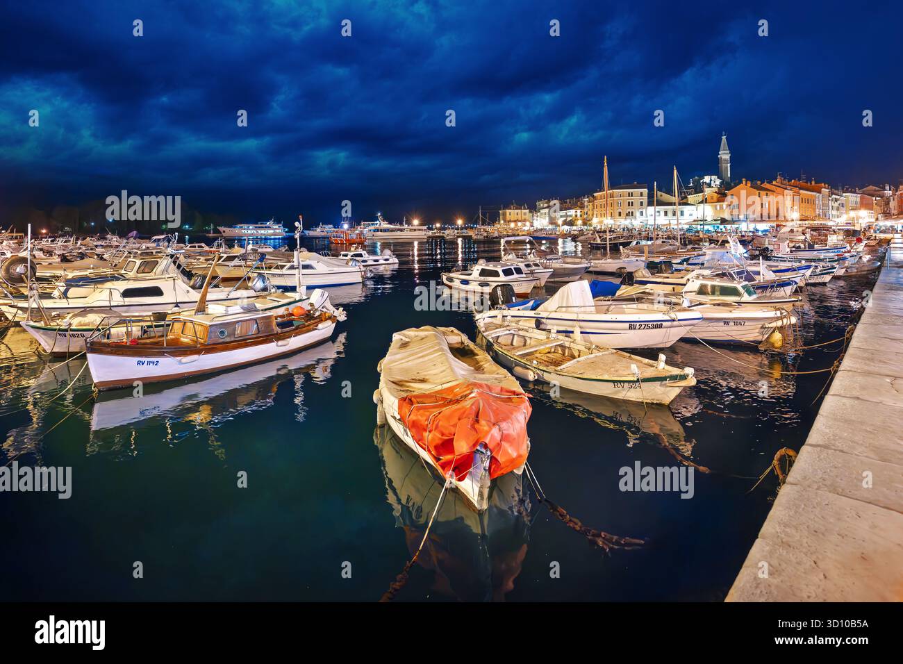 Les bateaux sont ancrés le long de la promenade du front de mer dans la baie de Rovinj, Croatie à Twilight. Banque D'Images