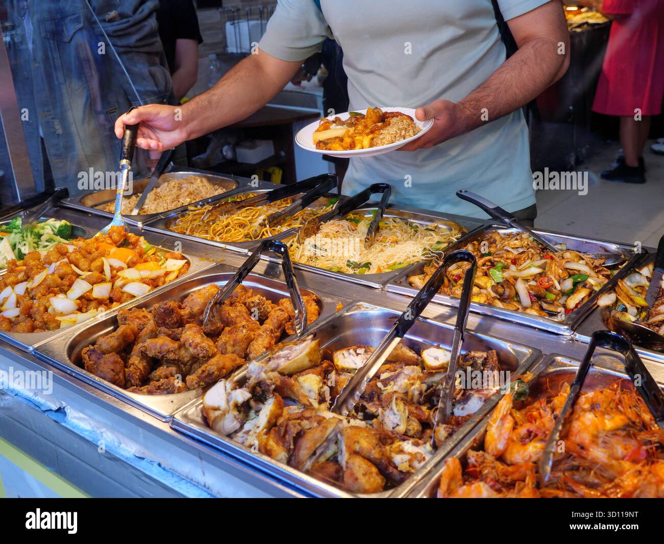 Les gens s'aidant eux-mêmes à un buffet à volonté dans un restaurant chinois à Chinatown, Londres, Royaume-Uni Banque D'Images
