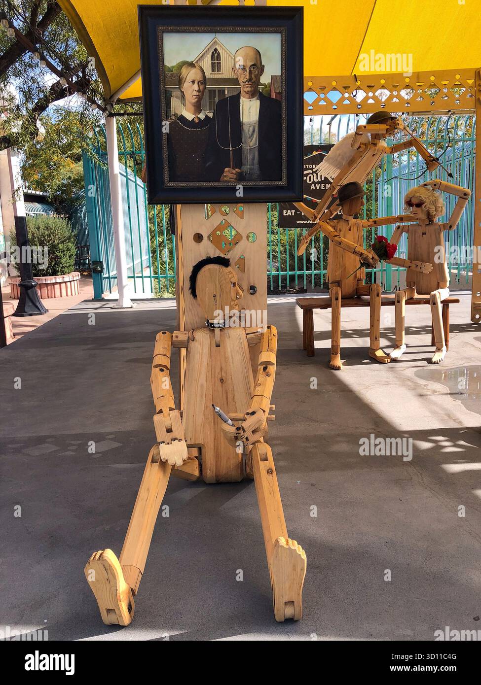 Des marionnettes en bois dansent autour d'un imprimé gothique américain encadré à Tucson, Arizona, mêlant charme de l'art populaire à une touche d'humour surréaliste. Banque D'Images