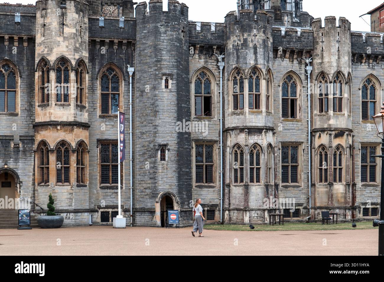 Cardiff, pays de Galles - 15 août 2022 : vue extérieure du château de Cardiff avec des fenêtres gothiques et un visiteur marchant dans la cour Banque D'Images