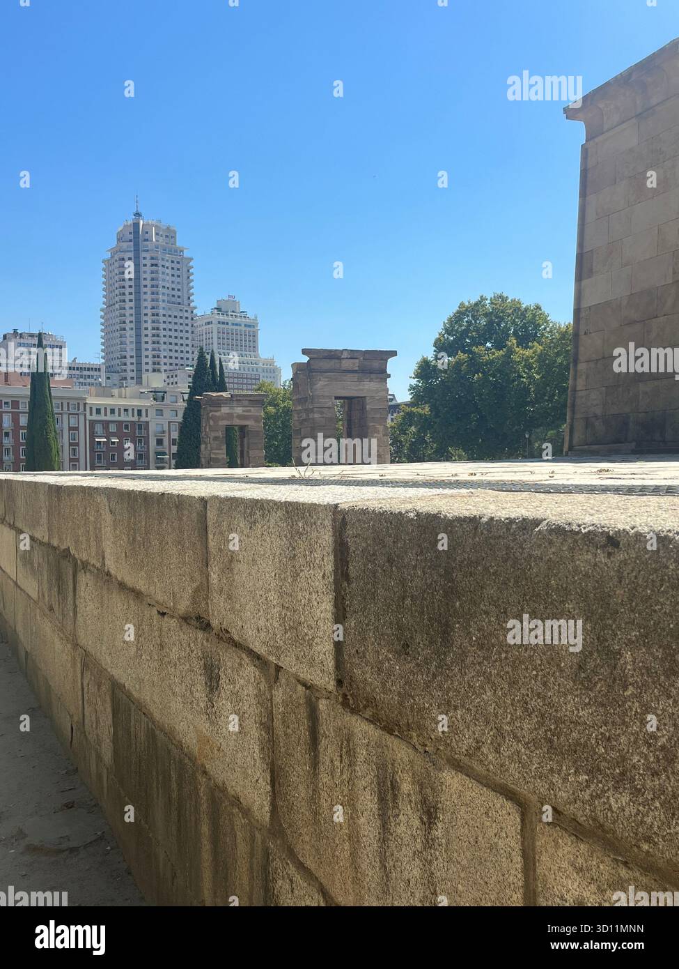 Vue latérale du Templo de Debod à Madrid, Espagne, avec l'hôtel Riu Plaza España en arrière-plan par une journée d'été ensoleillée. - Image de stock capturée avec un smartphone