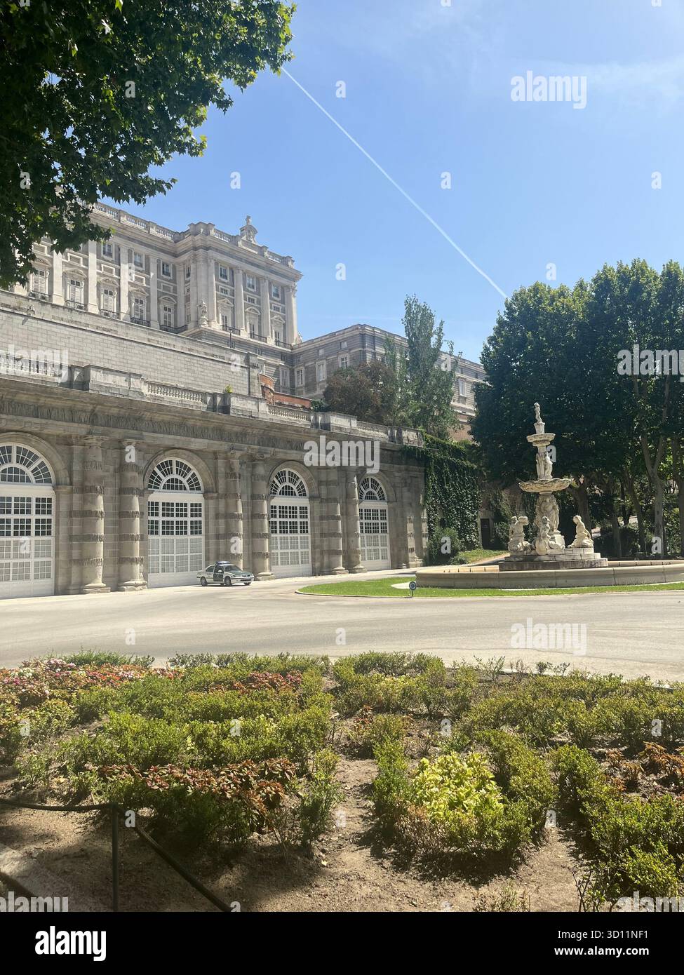 Vue sur les jardins du Campo del Moro à Madrid avec le Palais Royal et la fontaine centrale sous un ciel dégagé avec des traînées d'avion par une journée ensoleillée. - Image de stock capturée avec un smartphone