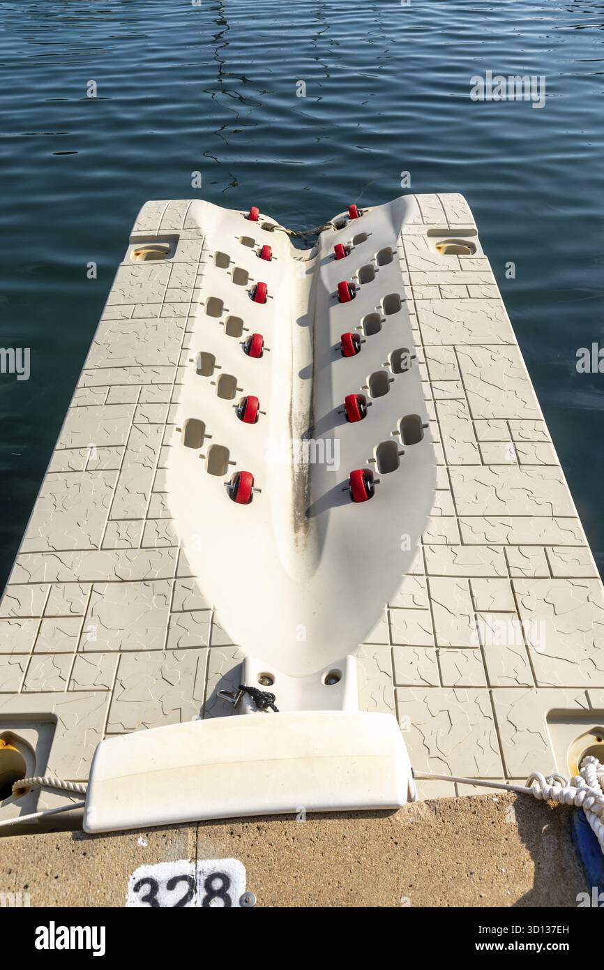Portisco - Sardinien - Italien - 02-23-2025 : plate-forme de quai flottante avec rouleaux rouges à Portisco, Sardaigne, conçue pour une mise à l'eau facile, ancrée Banque D'Images