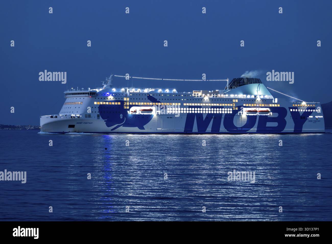Olbia - Sardinien - Italien - 02-18-2025 : Grand ferry Moby Fantasy illuminé la nuit, naviguant près d'Olbia avec des lumières brillantes reflétant sur le Banque D'Images