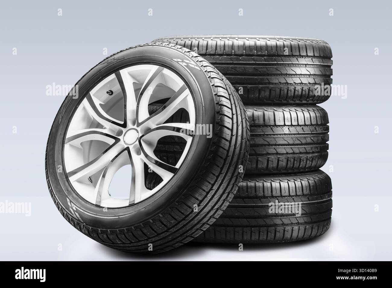 Une pile de pneus d'été et de jantes en alliage soigneusement disposées pour un accès facile, mettant en valeur leur conception et offrant d'excellentes performances de freinage à sec Banque D'Images