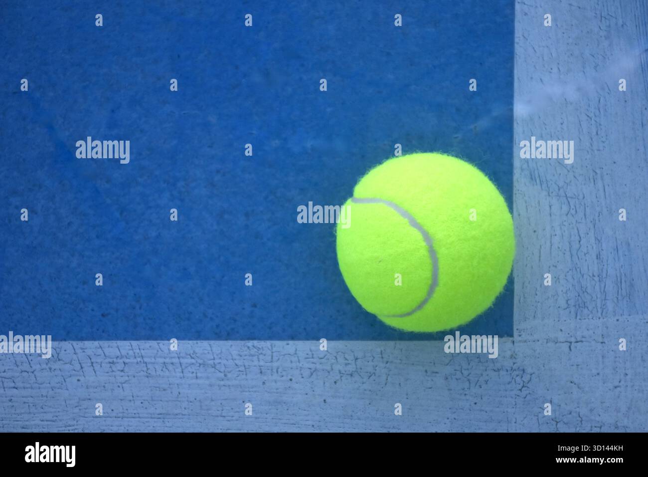terrain jaune de chute de balle de tennis avec bordure blanche sur sol bleu Banque D'Images