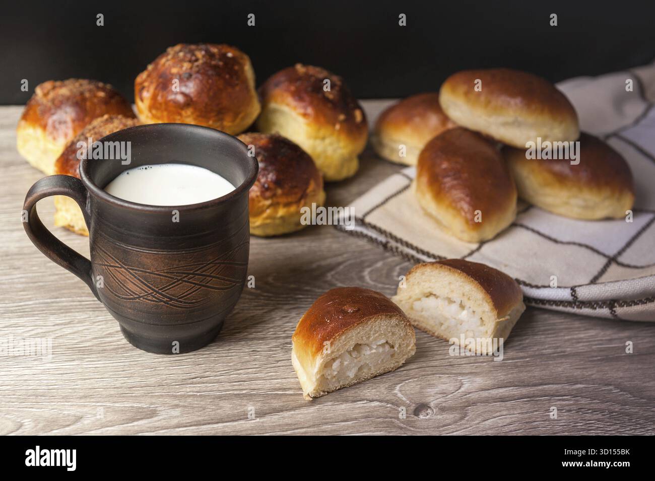 Petits pains et tartes et verre d'argile avec du lait Banque D'Images