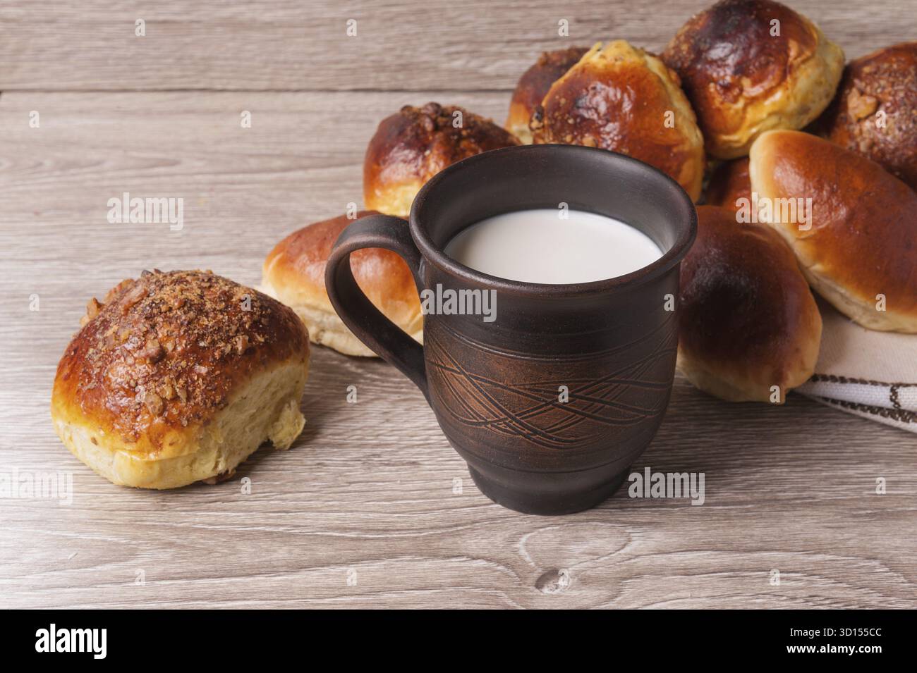 Petits pains et tartes et verre d'argile avec du lait Banque D'Images