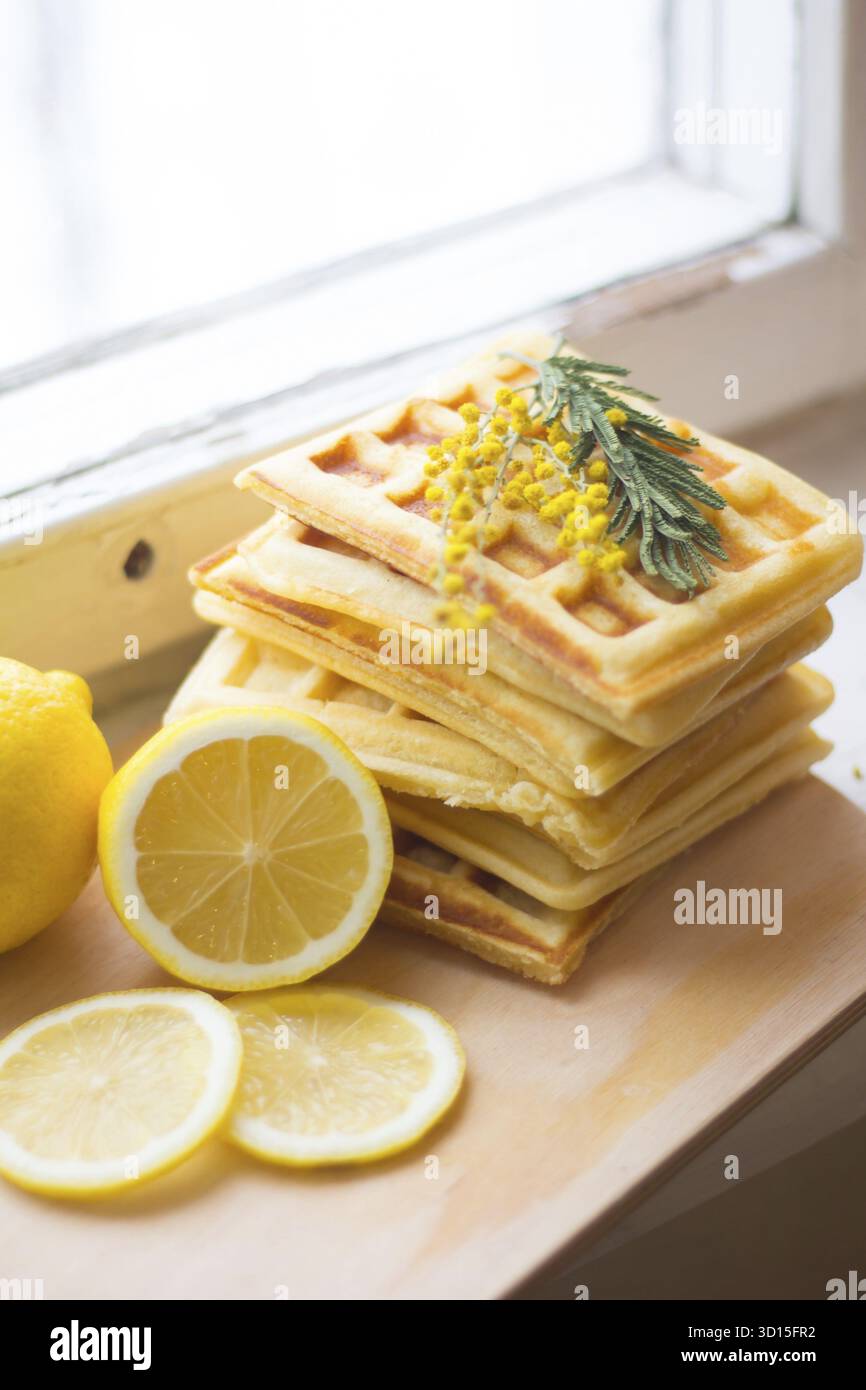 Pile les gaufrettes viennoises et tranches de citron. Tranches de citron sur une planche de bois. Les fruits sont hachés. Citron aigre. Les agrumes Banque D'Images
