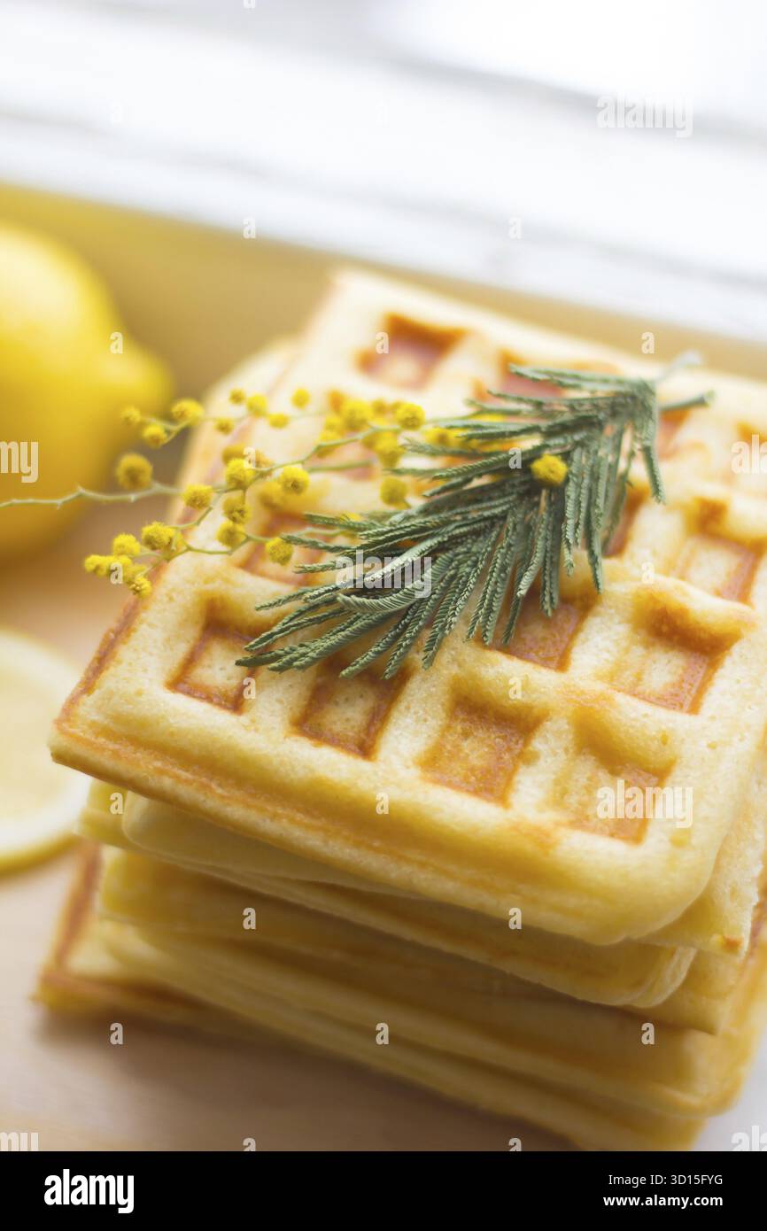 Pile les gaufrettes viennoises et tranches de citron. Tranches de citron sur une planche de bois. Les fruits sont hachés. Citron aigre. Les agrumes Banque D'Images