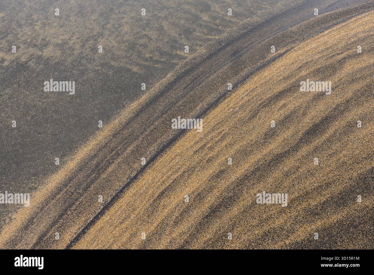 Motifs de sable de lave jaune et noir et de sable volcanique sur une plage dans l'eau, IJsland Banque D'Images