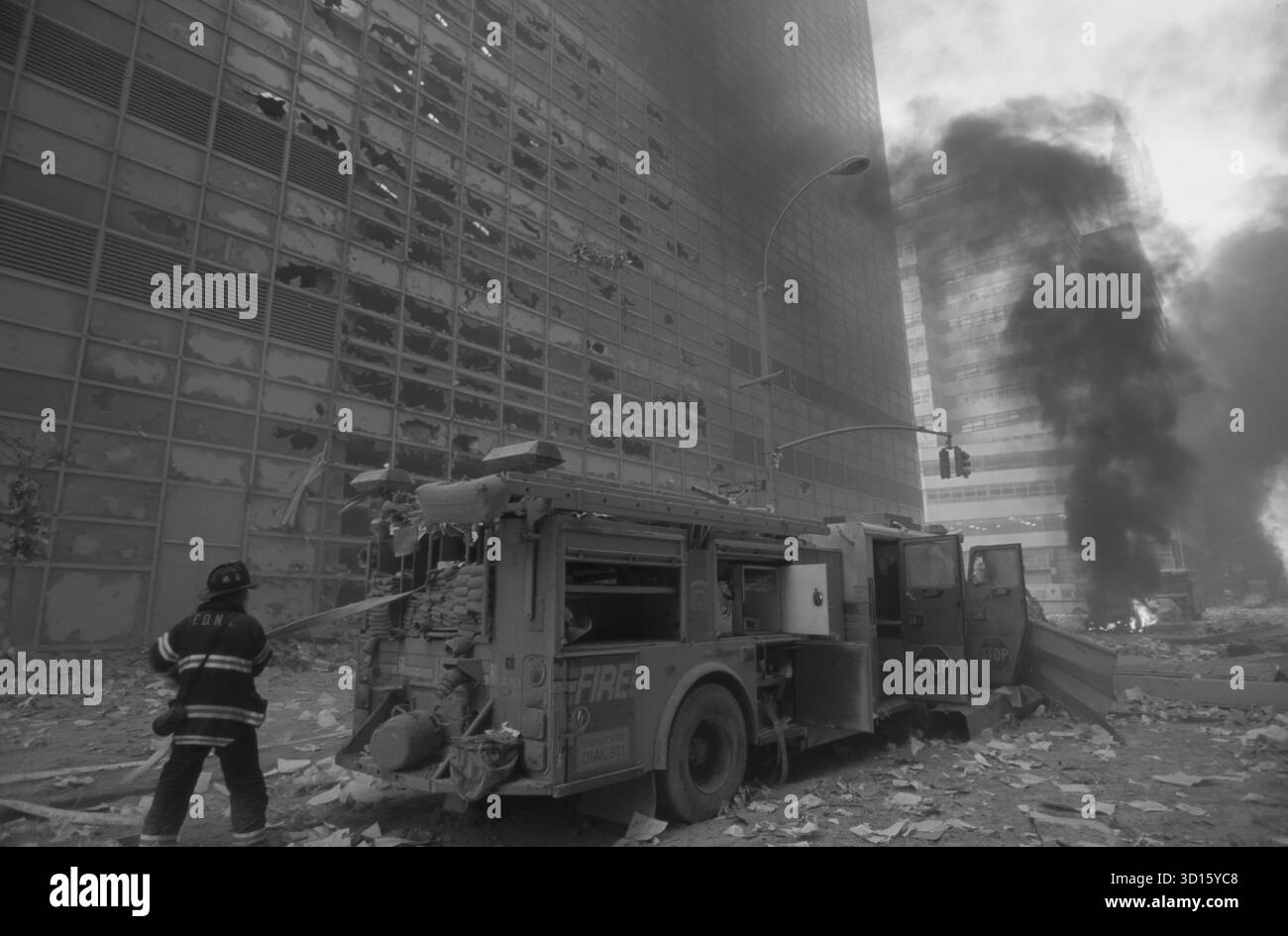 new-york-ville-pompier-tirant-tuyau d'eau-du-camion-pompier-au-milieu-débris-et-incendies le 9/11/2001 Banque D'Images