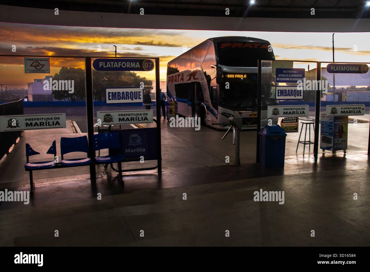 Marilia, SP, Brésil, 28 septembre 2025. Gares routières à Marilia, SP. Un bus à impériale attend à la plate-forme contre un beau lever de soleil doré, évoquant un Banque D'Images