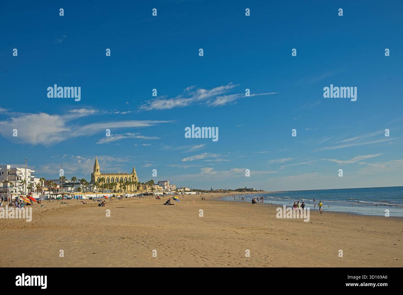Plage de Regla avec église et phare à Chipiona dans la lumière chaude du soir Banque D'Images