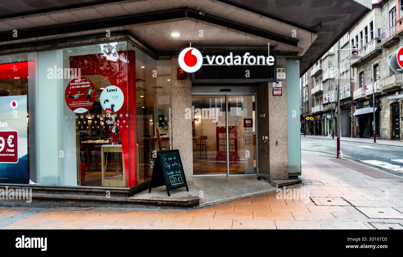 Magasin Vodafone à Pontevedra, Espagne, avec façade en verre moderne, signalisation et affichages promotionnels, situé le long d'une rue commerçante urbaine animée. Banque D'Images