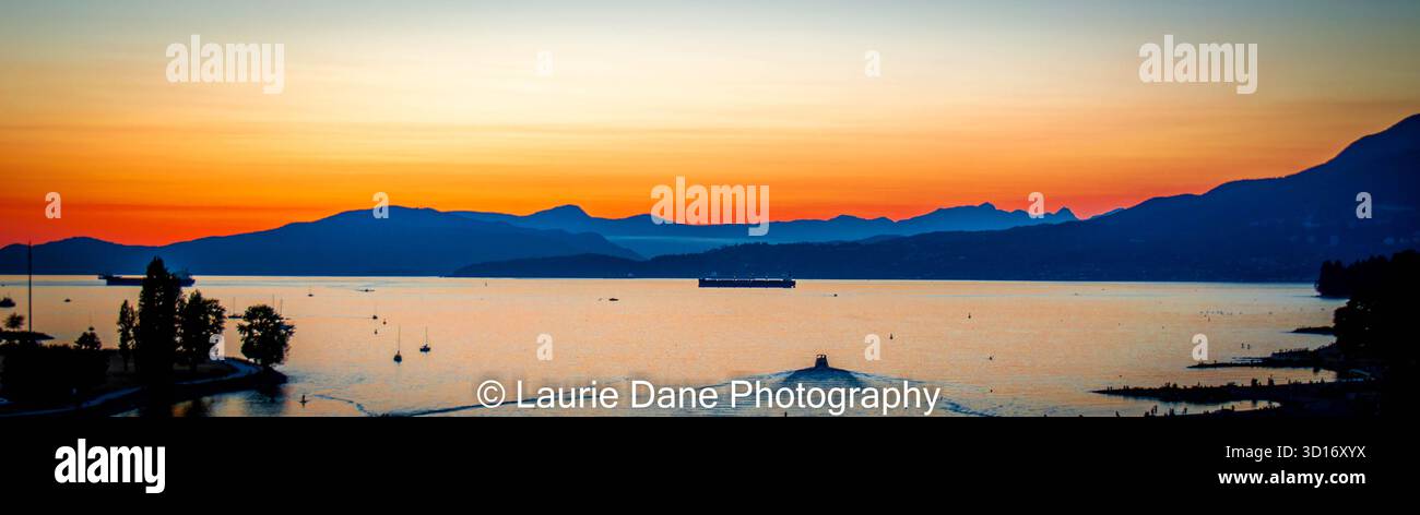 Coucher de soleil sur Calm Bay avec Ferry et montagnes silhouettées Banque D'Images