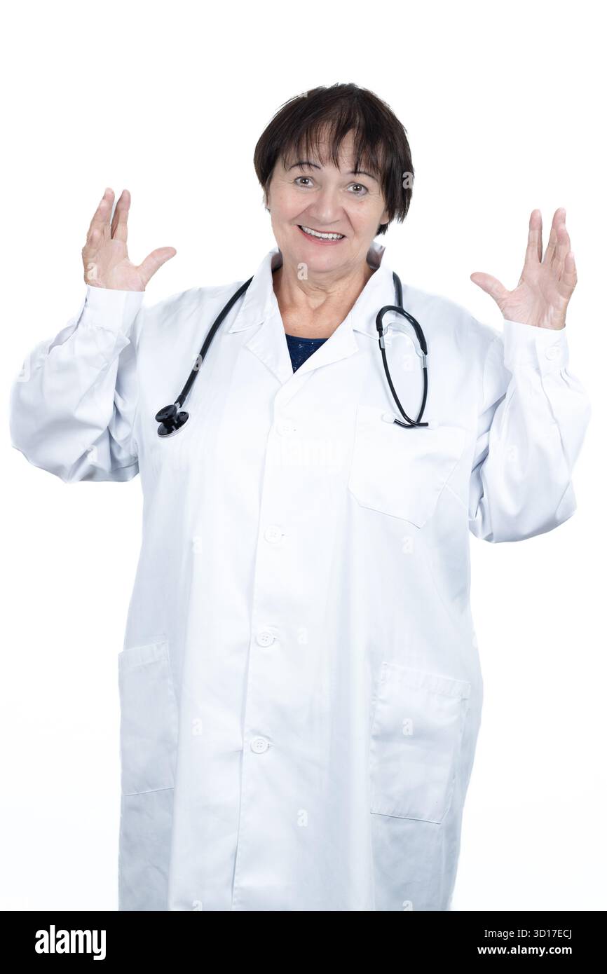 Médecin senior femme portant une blouse de laboratoire blanche et stéthoscope, souriant tout en faisant des gestes avec confiance avec les deux mains vers le haut, montrant l'expertise médicale et co Banque D'Images