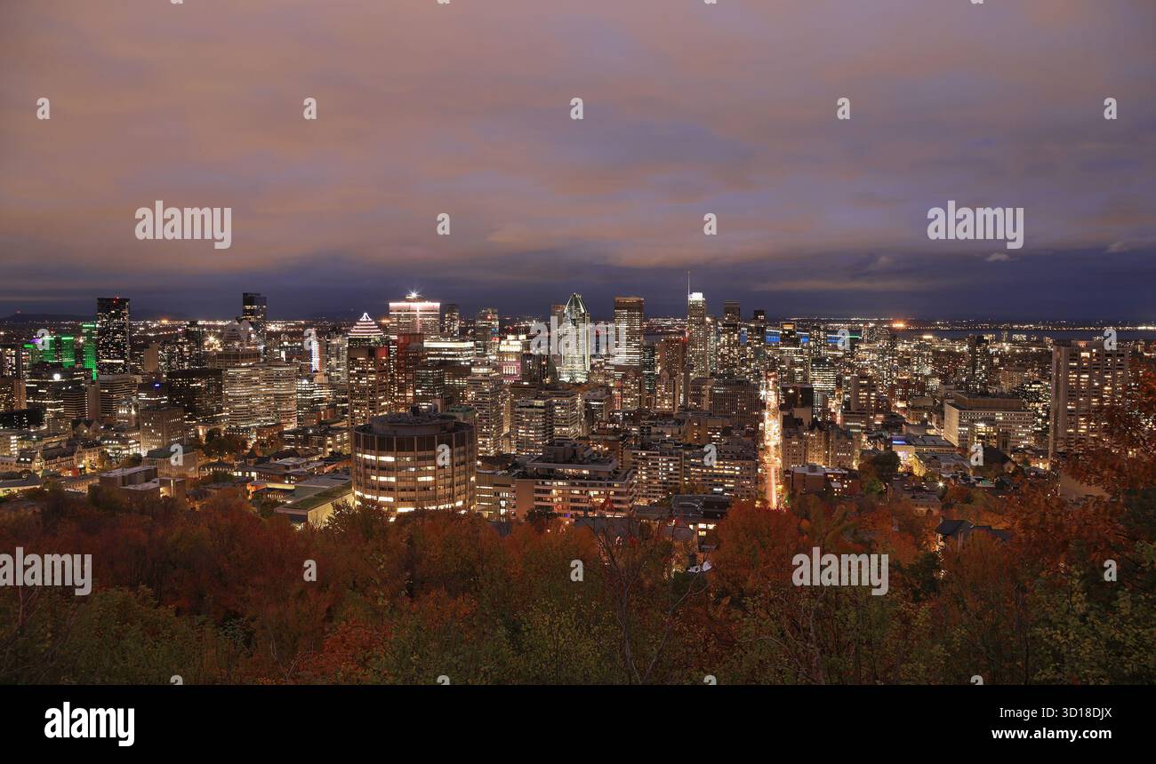 Horizon aérien de Montréal illuminé au crépuscule avec des couleurs d'automne et le fleuve Saint-Laurent sur le fond, Canada Banque D'Images