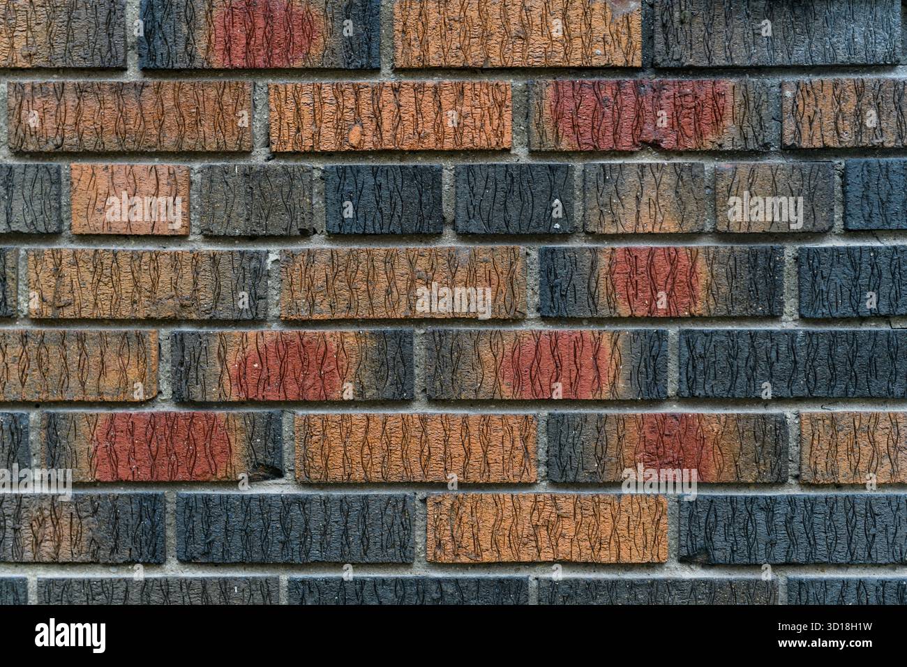 Détail abstrait de plusieurs rangées de briques texturées multicolores. Banque D'Images