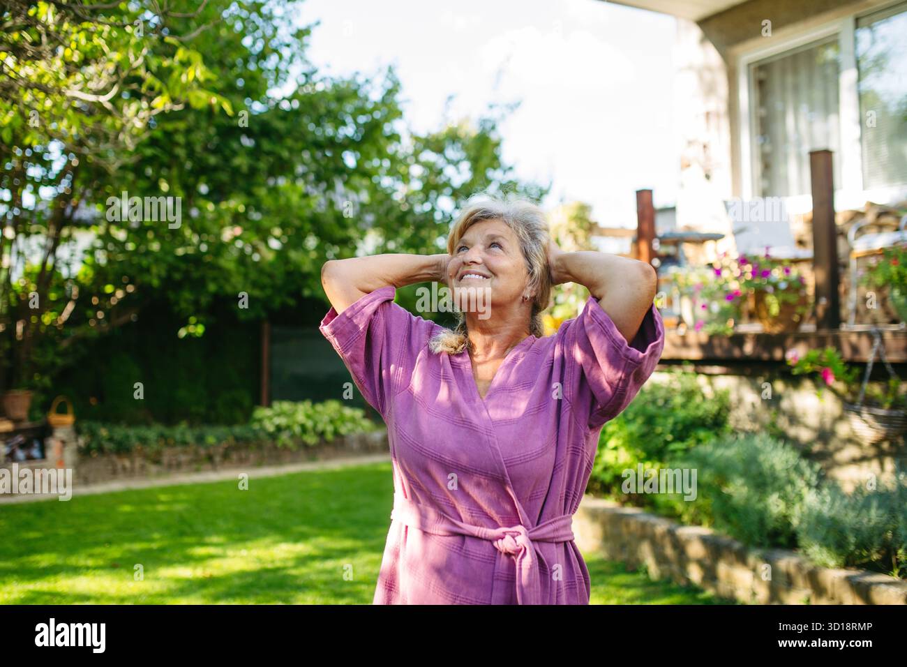 Belle femme âgée faisant du yoga dans le jardin, routine matinale. Banque D'Images