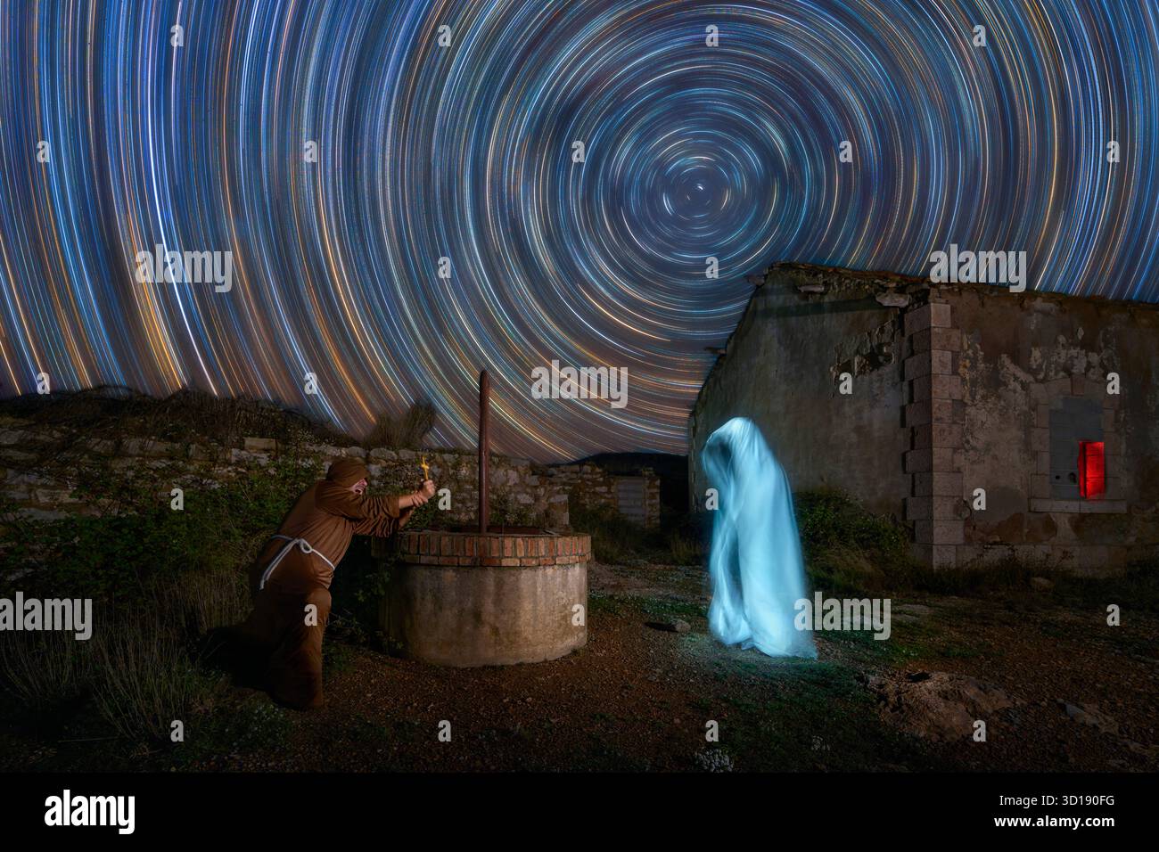 Scène avec un moine combattant un fantôme la nuit avec des startrails dans le ciel, dans une station abandonnée avec un puits. Banque D'Images