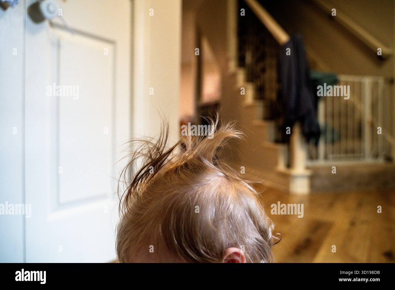 Vue de côté de Messy Toddler Girl Hair dans la maison familiale Banque D'Images