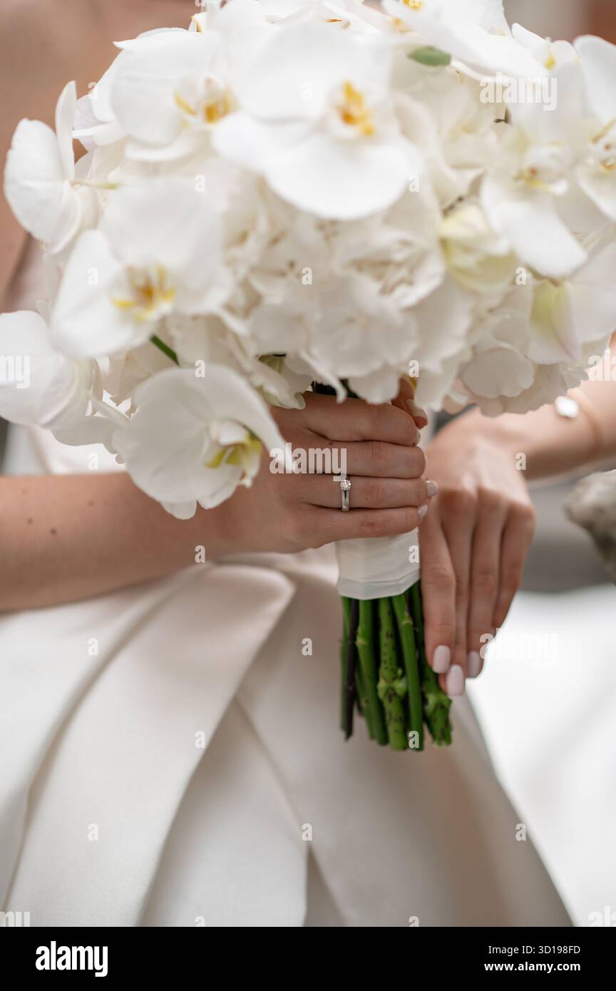Mariée tenant un bouquet d'orchidée blanche gros plan Banque D'Images
