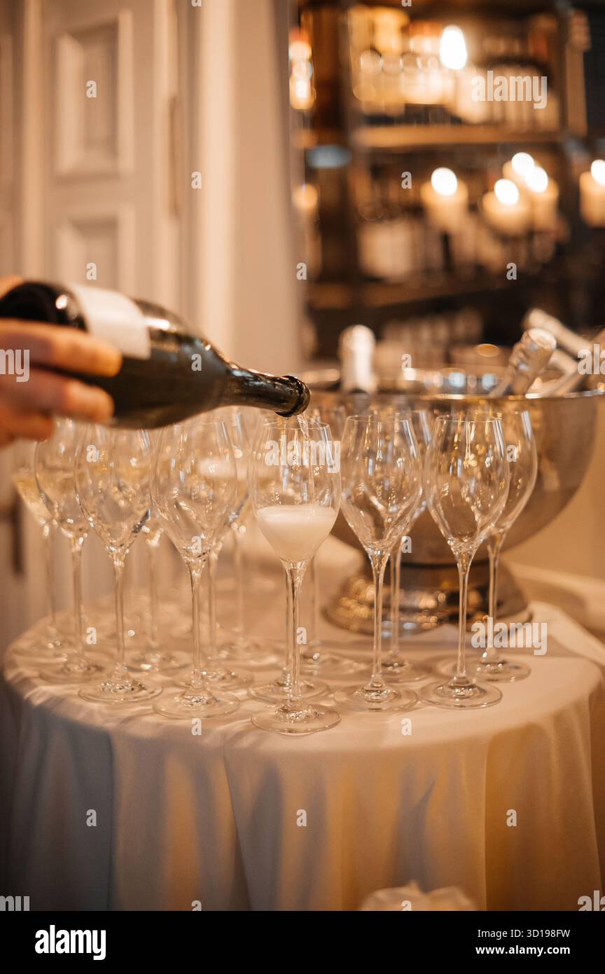 Verser du champagne dans des verres à vin Banque D'Images