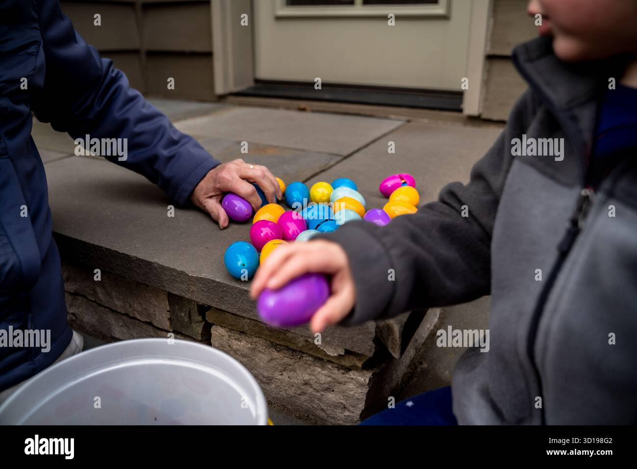 Gros plan de grand-mère et petit-fils collectant des œufs de Pâques en plastique Banque D'Images