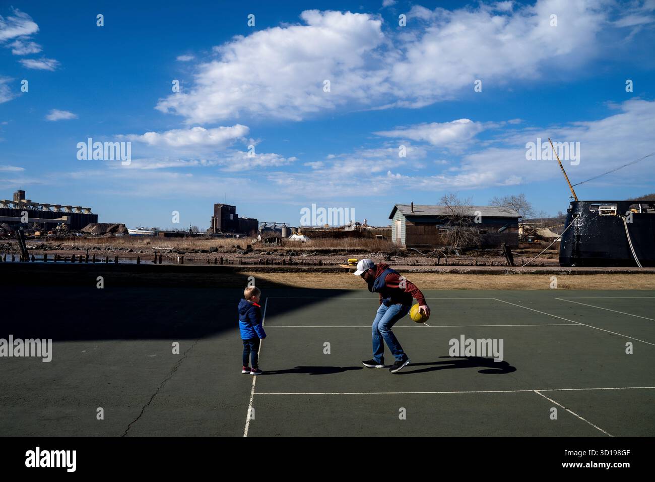 Père dribble Basketball avec son fils sur le terrain de sport extérieur à Sun Banque D'Images