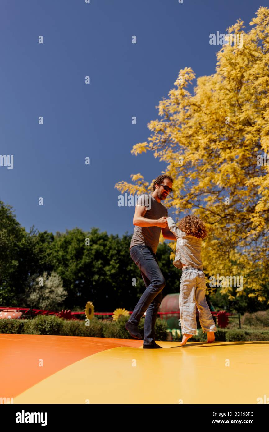Homme et enfant jouant sur le videur extérieur coloré Banque D'Images