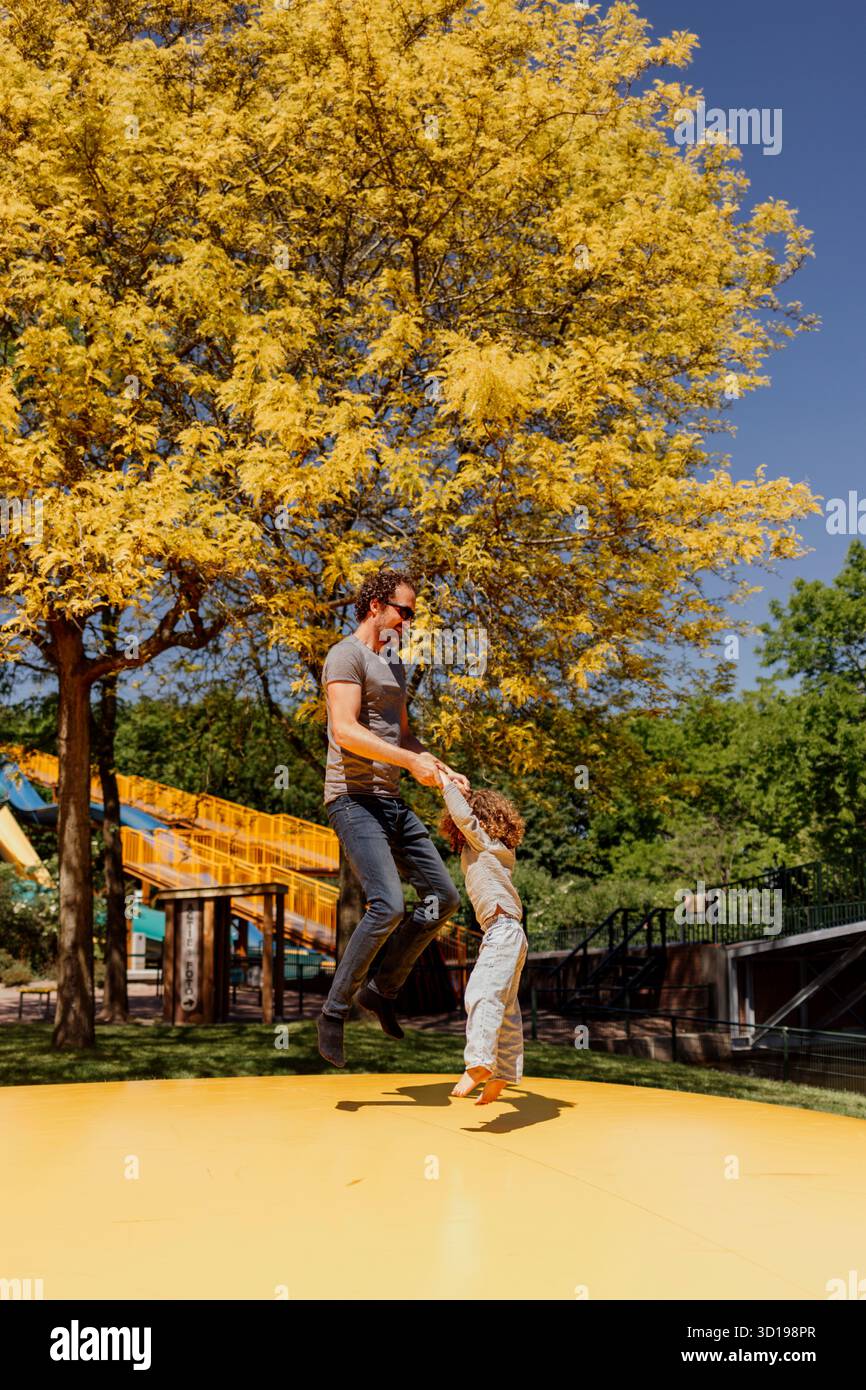 Homme et enfant jouant sur le videur extérieur coloré Banque D'Images