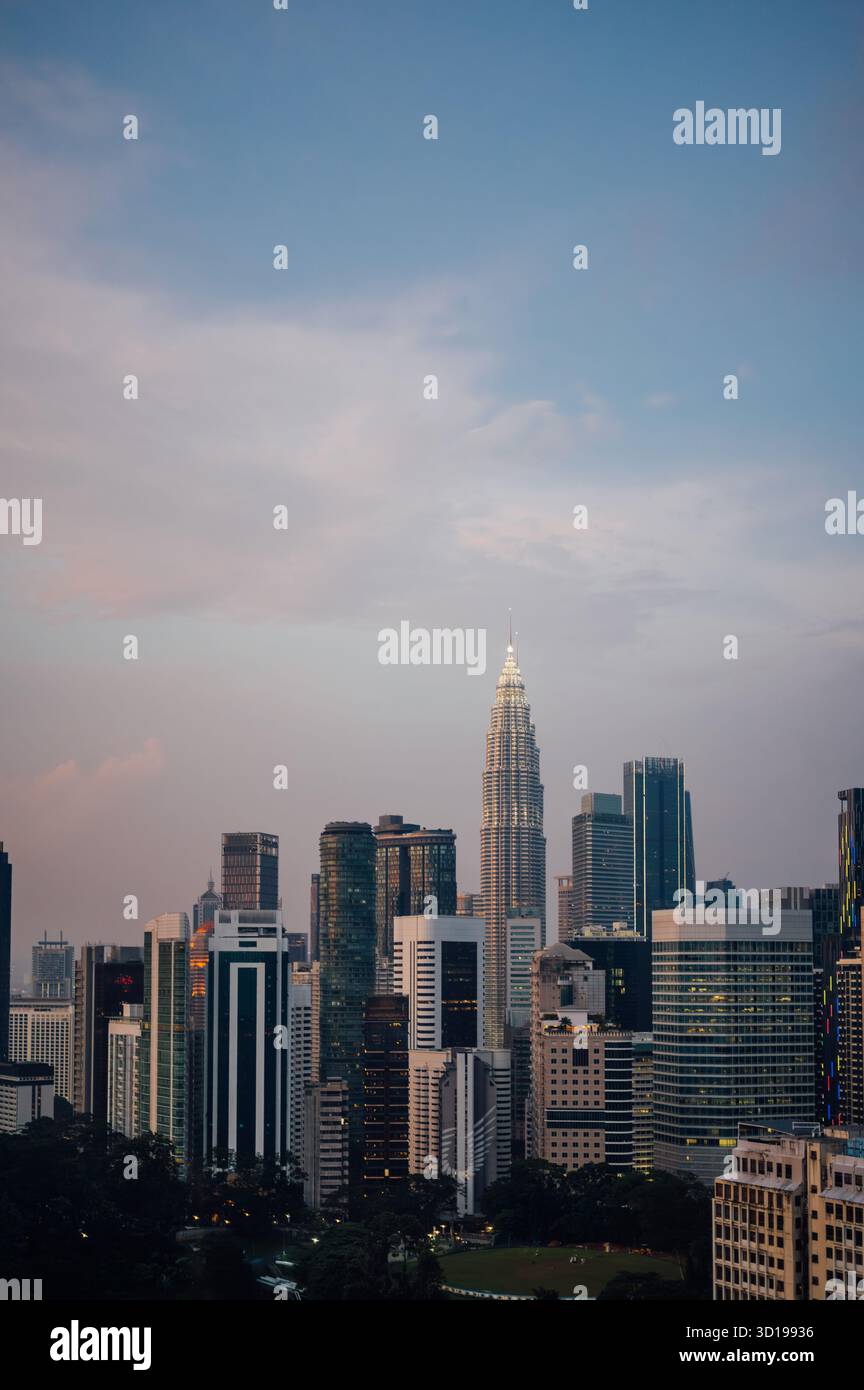 Tour Petronas illuminée au crépuscule, Kuala Lumpur Skyline, Malaisie Banque D'Images
