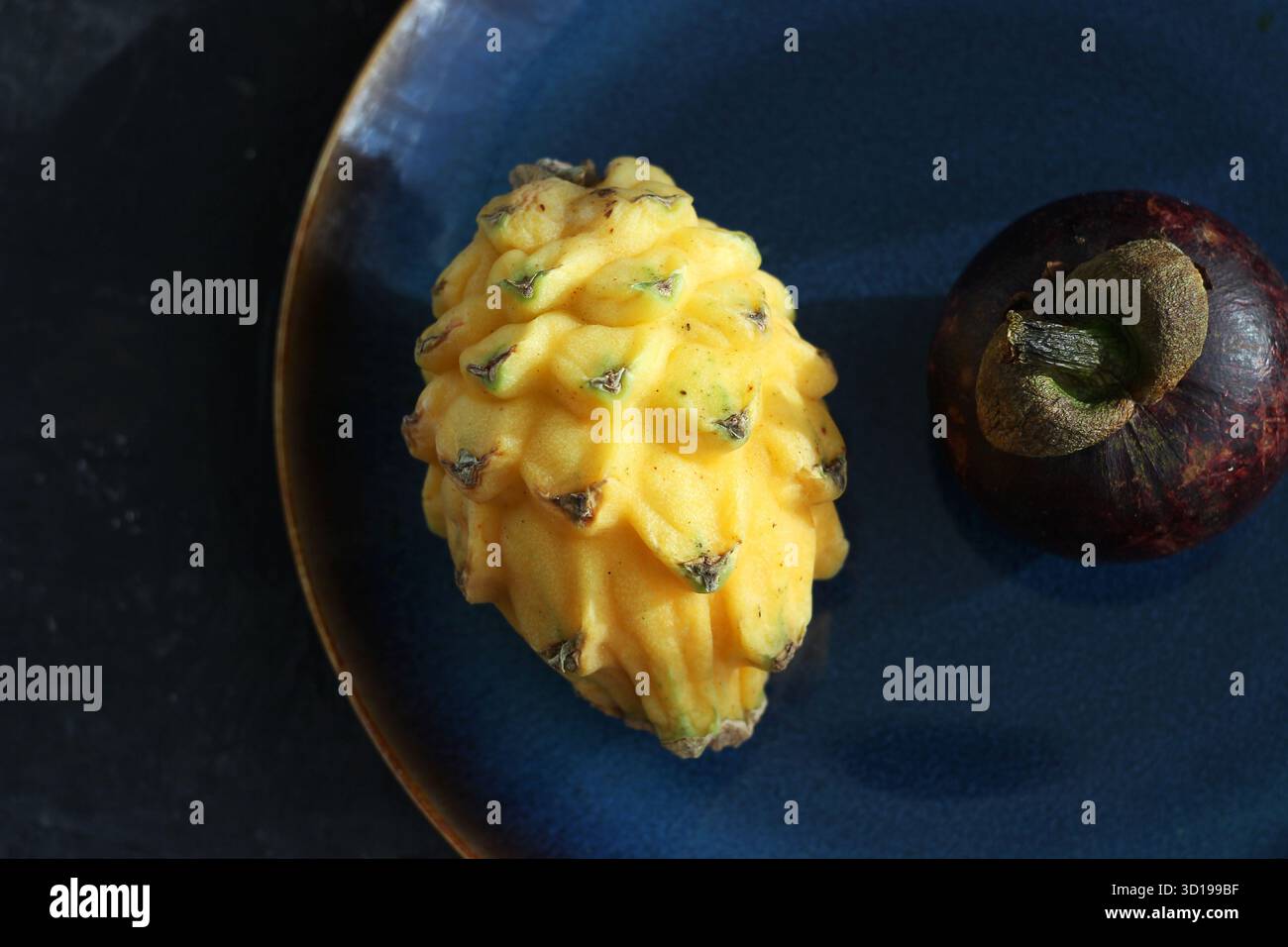 pitaya jaune et mangoustan reposent dans une assiette sur la table Banque D'Images