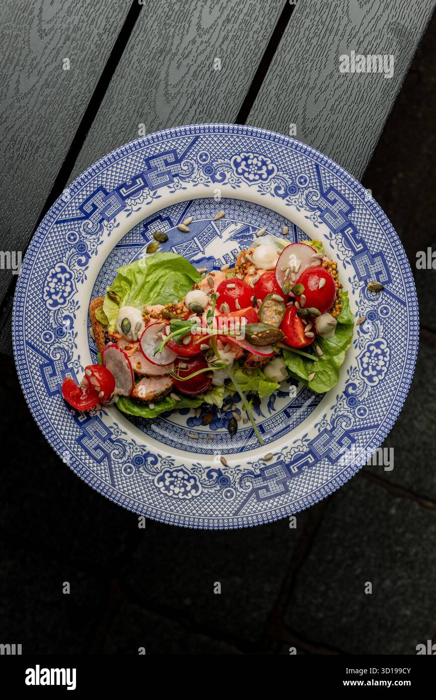 Sandwich à la tomate et au poisson sur une assiette bleue d'automne Banque D'Images