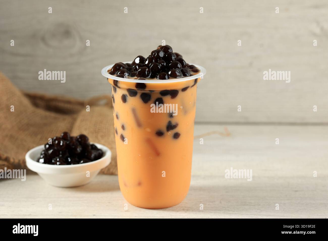 Thé au lait thaïlandais glacé avec Boba Pearl ou thaï Bubble Tea en plastique To Go Cup sur fond blanc Banque D'Images