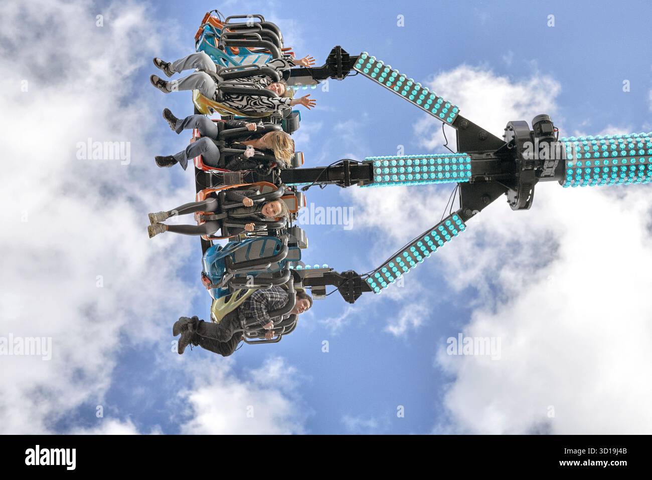 Frissons de foire avec participants suspendus dans les airs. Balade à balancier tourbillon avec vue de dessous. Angleterre, Royaume-Uni Banque D'Images