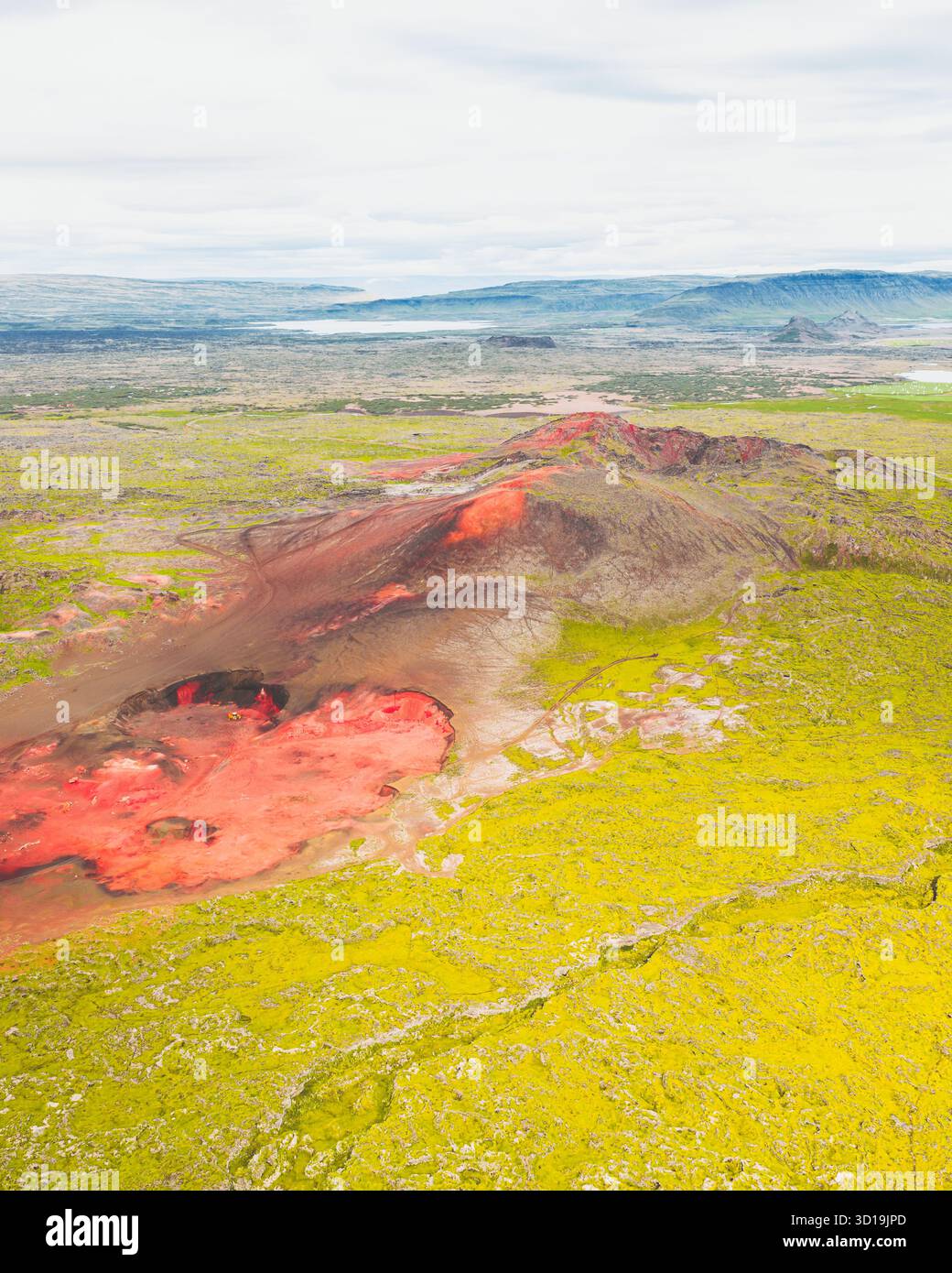 Vue aérienne d'un paysage volcanique rouge saisissant contrastant avec la végétation verte vibrante environnante, Heydalsvegur, Islande. Banque D'Images