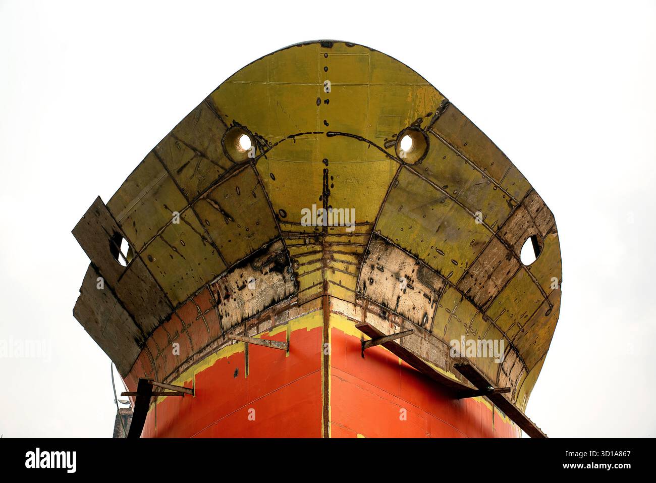 Gros plan de la coque de navire rouge et or avec des hublots pour navire industriel Banque D'Images