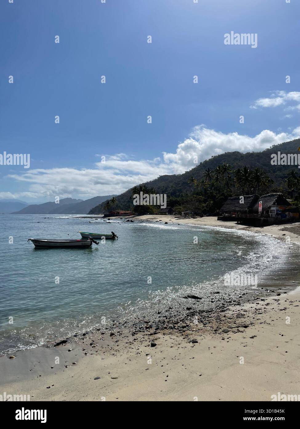 Plage tropicale paisible avec des bateaux de pêche et des collines couvertes de palmiers sous un ciel bleu clair, Quimixto, mexique - Image de stock capturée avec un smartphone