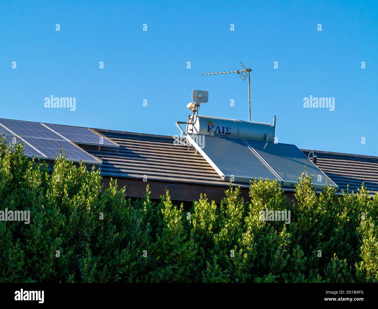 Chauffe-eau solaire et panneaux solaires photovoltaïques sur le toit d'un bâtiment à Chypre une île de la Méditerranée. Banque D'Images
