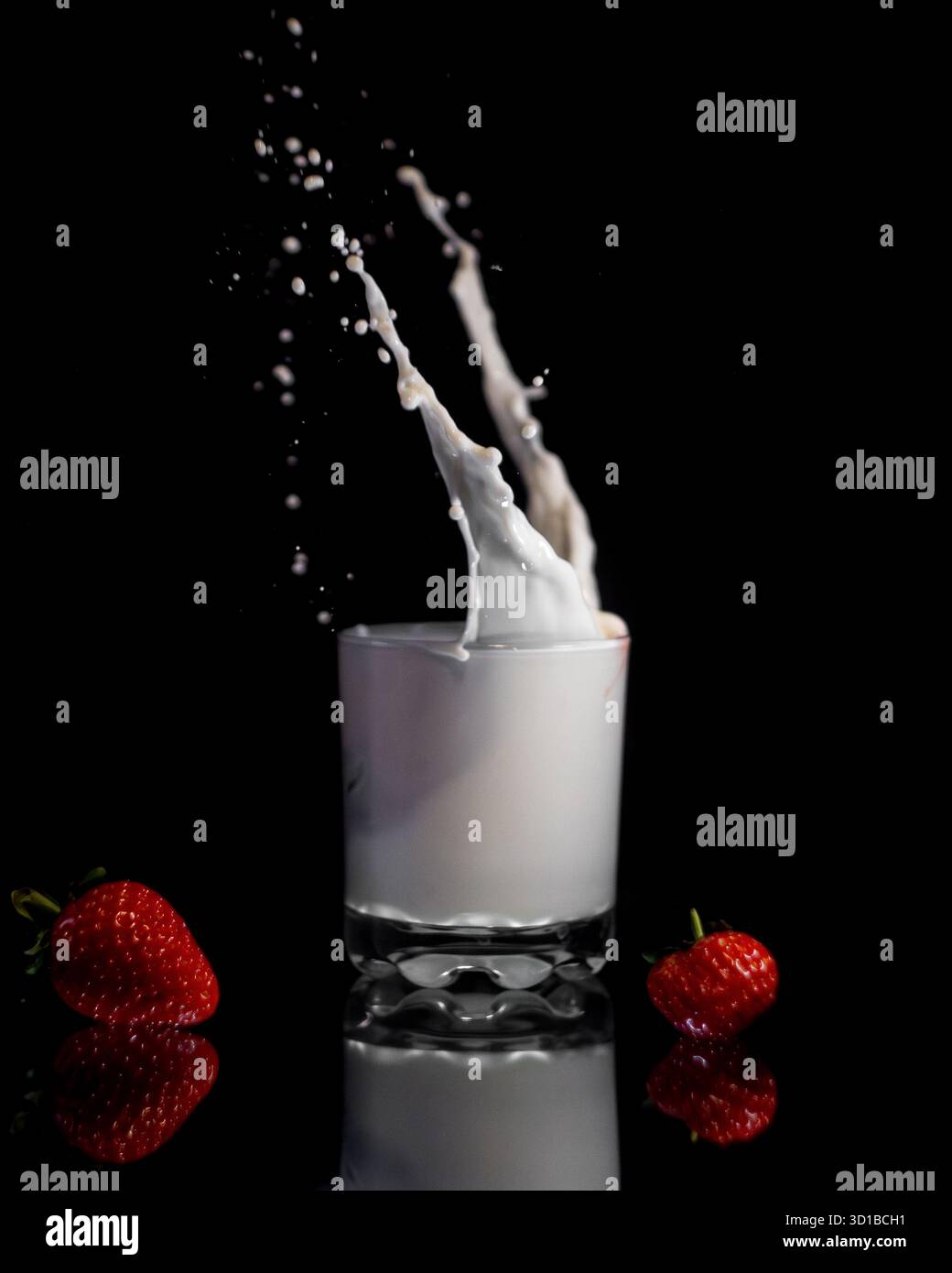 Éclaboussures de lait et fruits réfléchis Banque D'Images