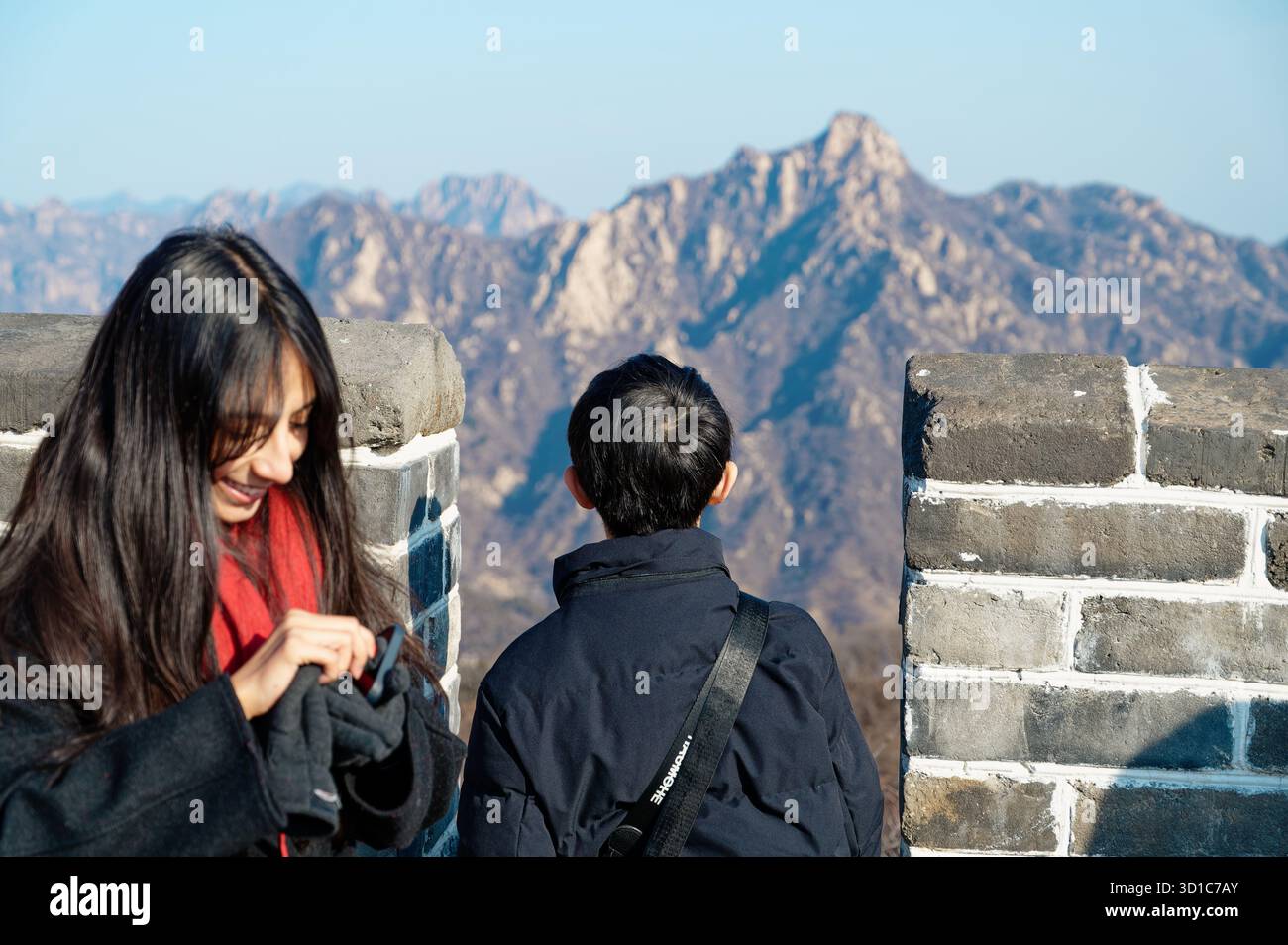 Une femme sourit comme un enfant regarde la chaîne de montagnes de la Grande Muraille de Chine Banque D'Images