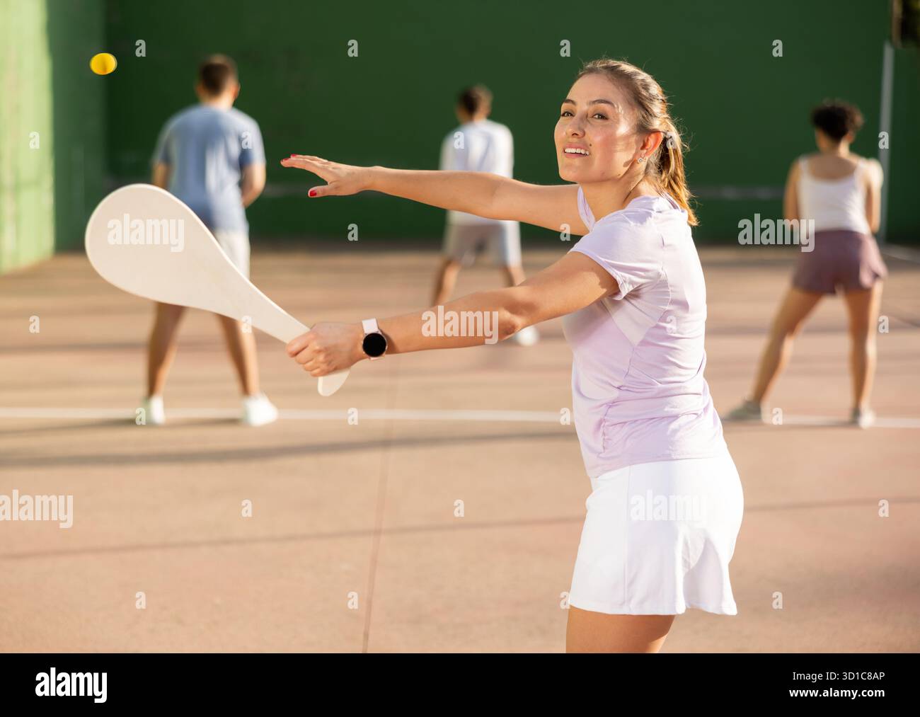 Femme basque pelote joueur frapper balle avec raquette en bois Banque D'Images
