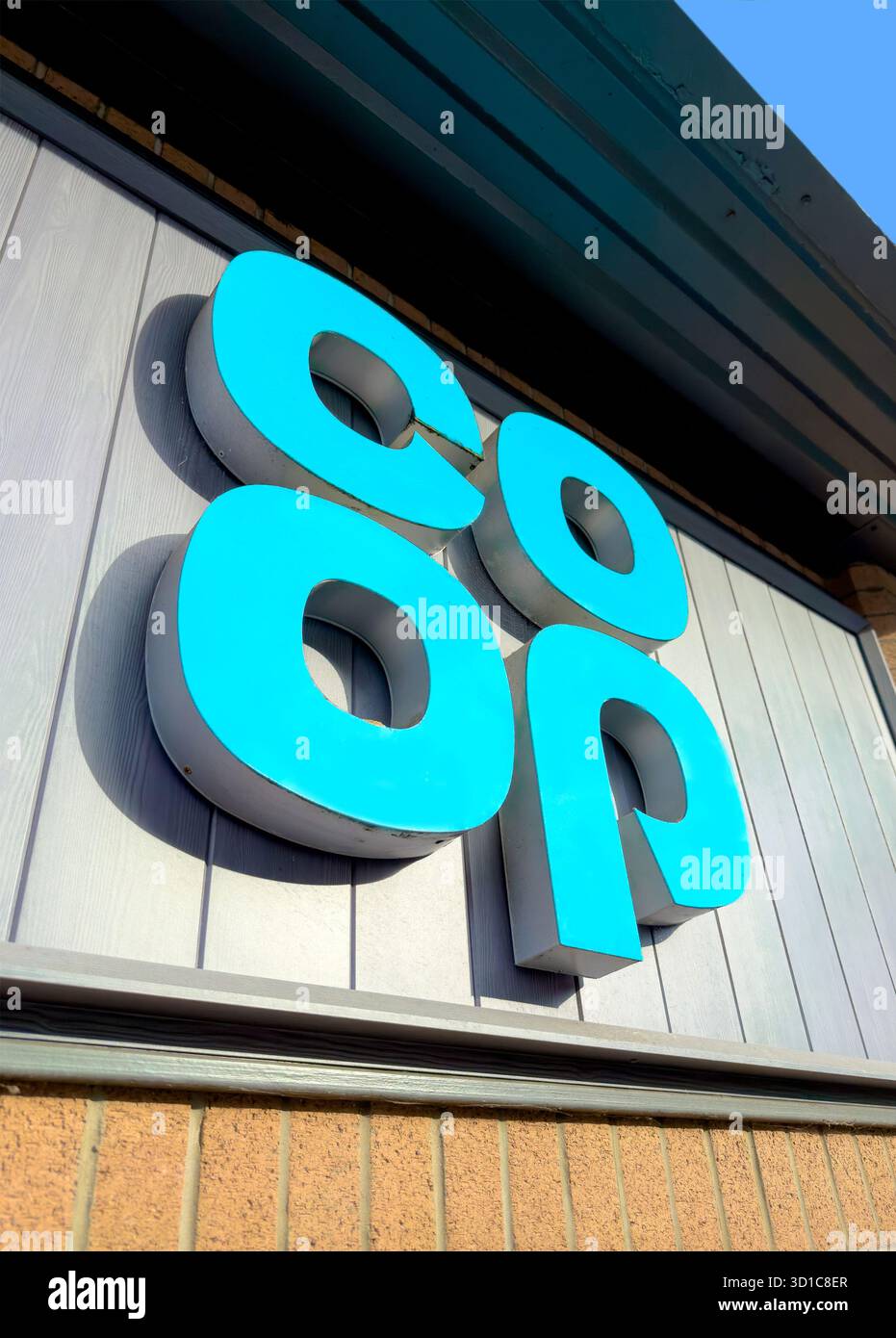 Gros plan du logo du supermarché Co-op sur la façade extérieure d'un magasin avec des panneaux et des briques modernes à Prudhoe northumberland - Image de stock capturée avec un smartphone