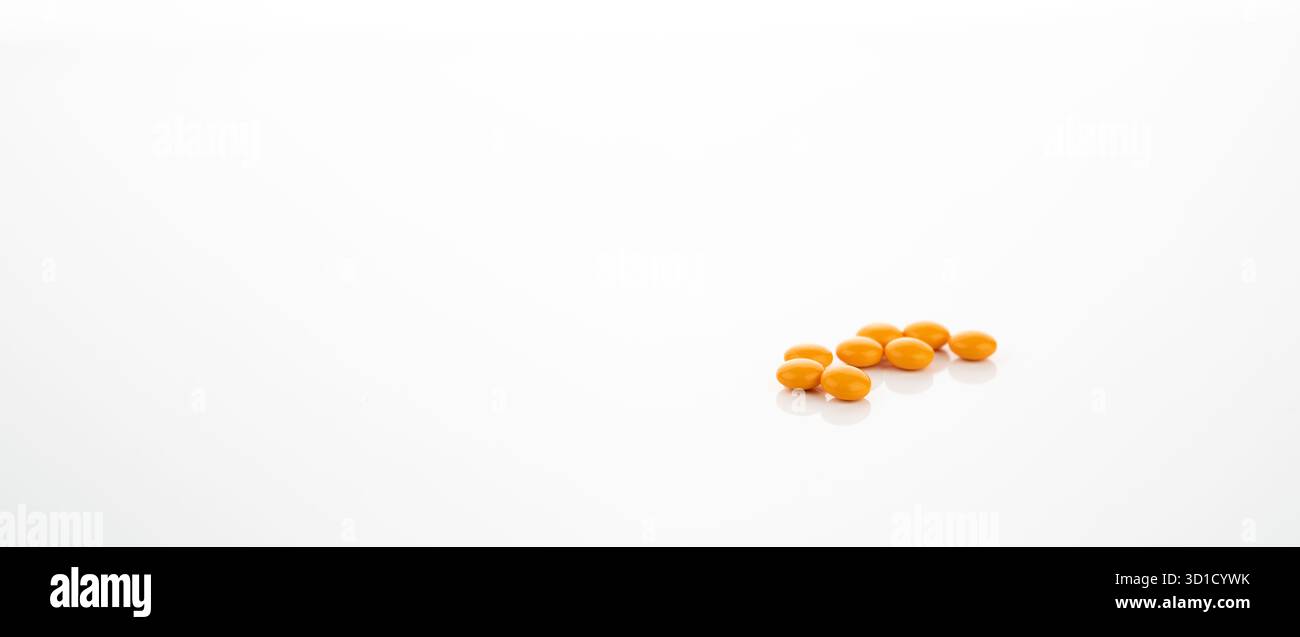 Comprimés enrobés de sucre jaune sur fond blanc pour la recherche pharmaceutique, la découverte de médicaments et le développement de nouveaux médicaments dans l'industrie des soins de santé. Banque D'Images